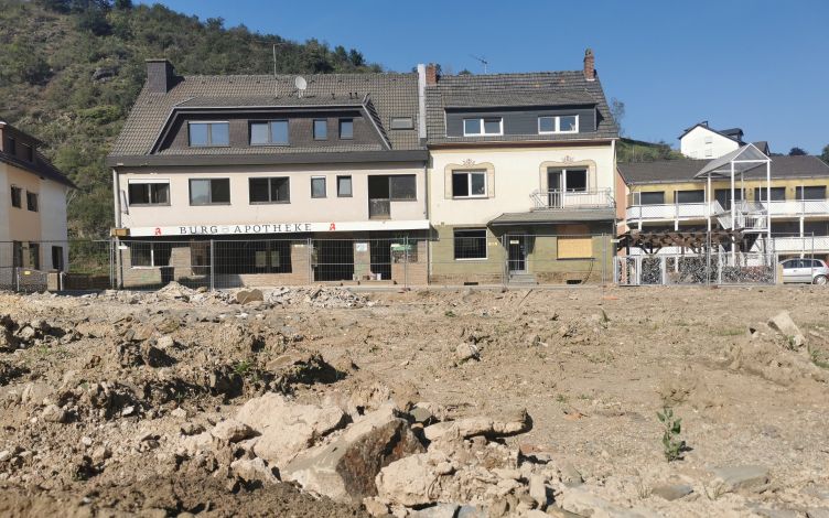 A pharmacy located beside a damaged hillside.