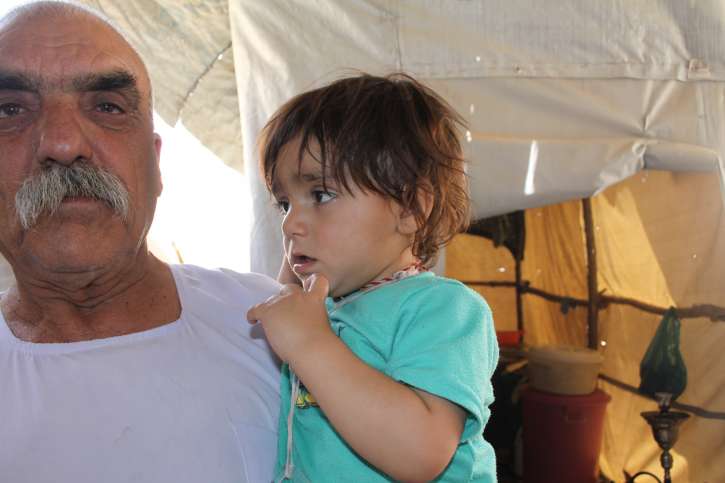 Der kleine Falah mit seinem Großvater im Flüchtlingscamp Esyan.
