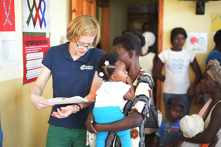 action-medeor Mitarbeiterin mit Mutter und Kind in Klinik in Haiti