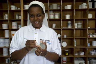 Une infirmière étiquette une boîte de médicaments dans une pharmacie au Zimbabwe.