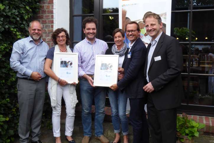 Herr Hülsemann (rechts) übergibt neuen Mitgliedern  der Unternehmer-Initiative Niederrhein ihre Urkunden.