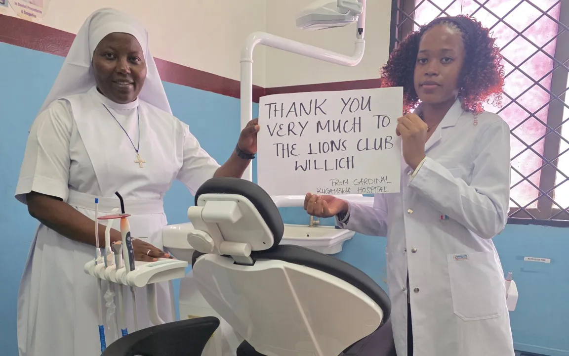 Two women are holding a sign that reads, “Thank you very much to Lions Club Willich from Cardinal Rugambwa Hospital.”