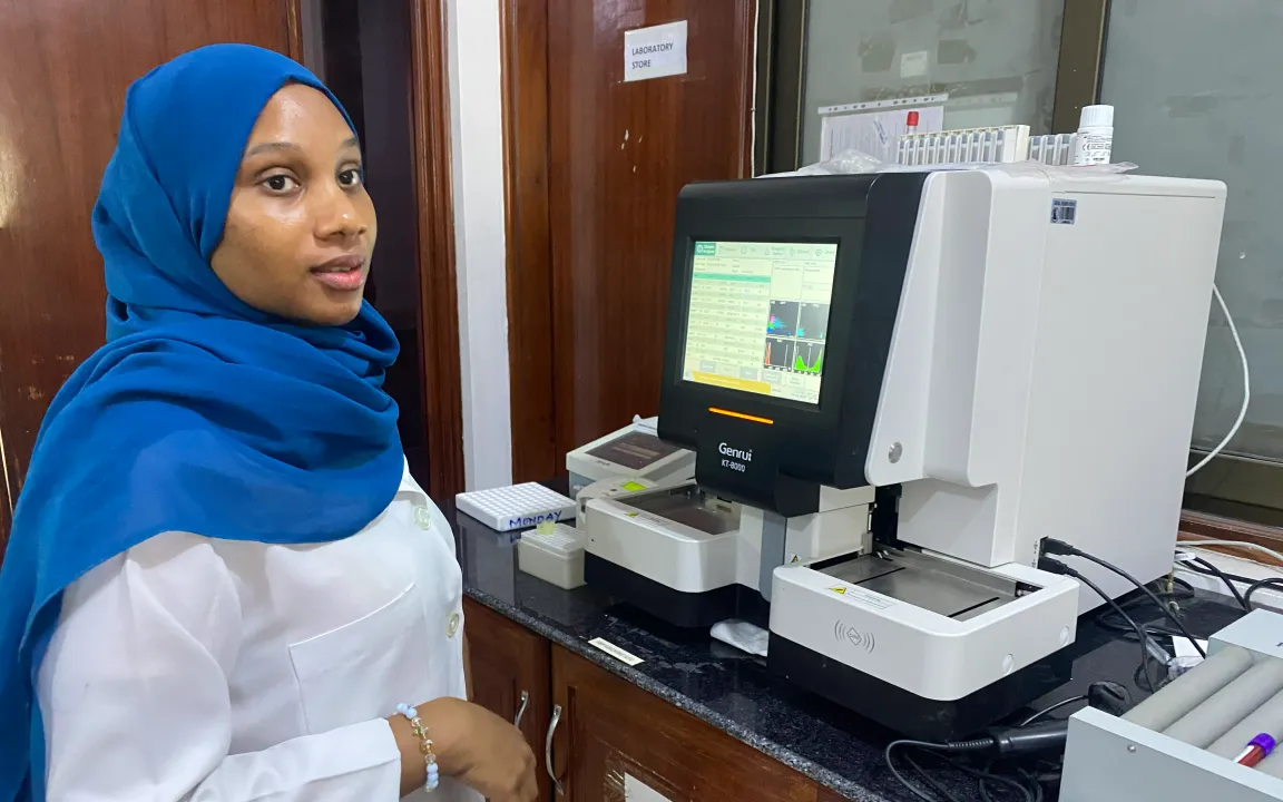 A woman is standing in front of a piece of medical equipment.