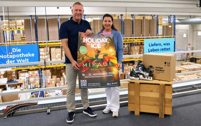 Ein Mann und eine Frau halten ein Plakat von Holiday on Ice.