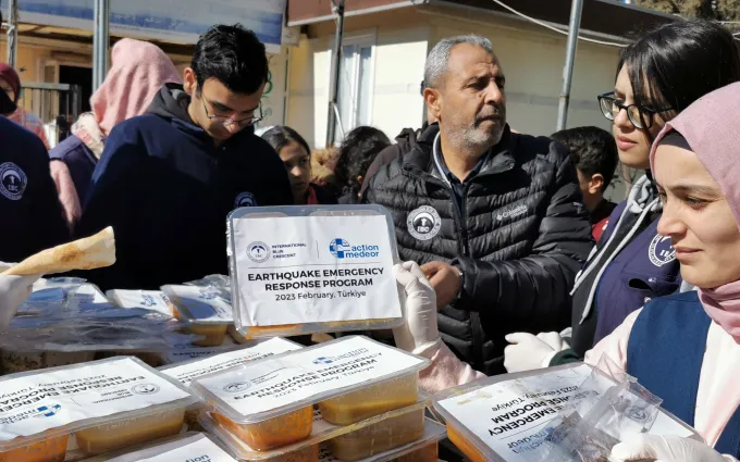 Employees distribute the packed meals to the earthquake victims.
