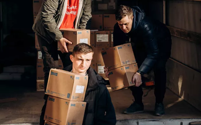 Parcels are loaded from a truck by three helpers in Ukraine
