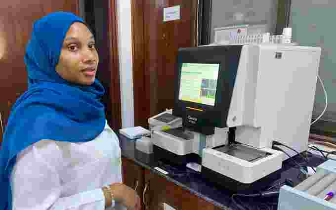 A woman is standing in front of a piece of medical equipment.