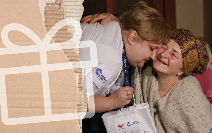 A woman in white medical clothing hands an elderly lady a bag of medication.
